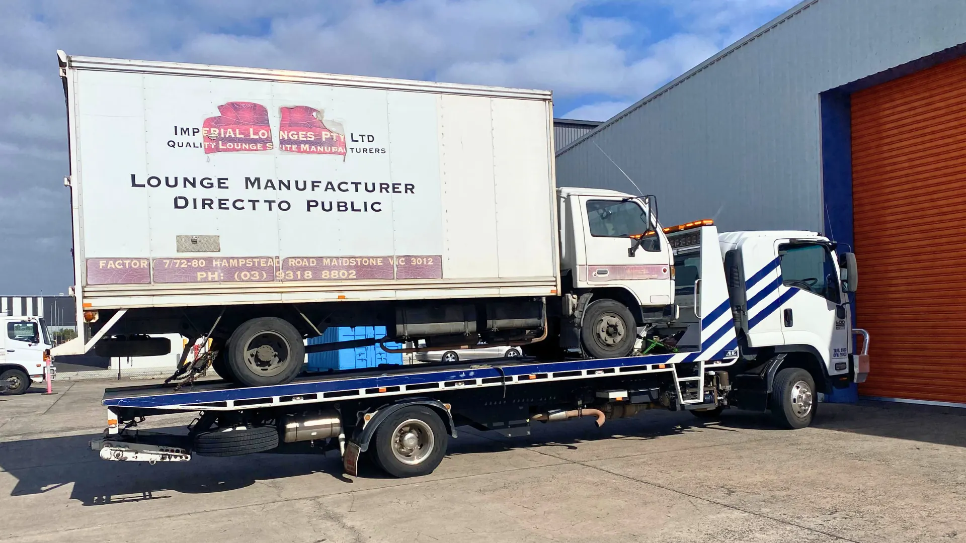 White Imperial Lounges box truck loaded on the All Over Towing tilt tray