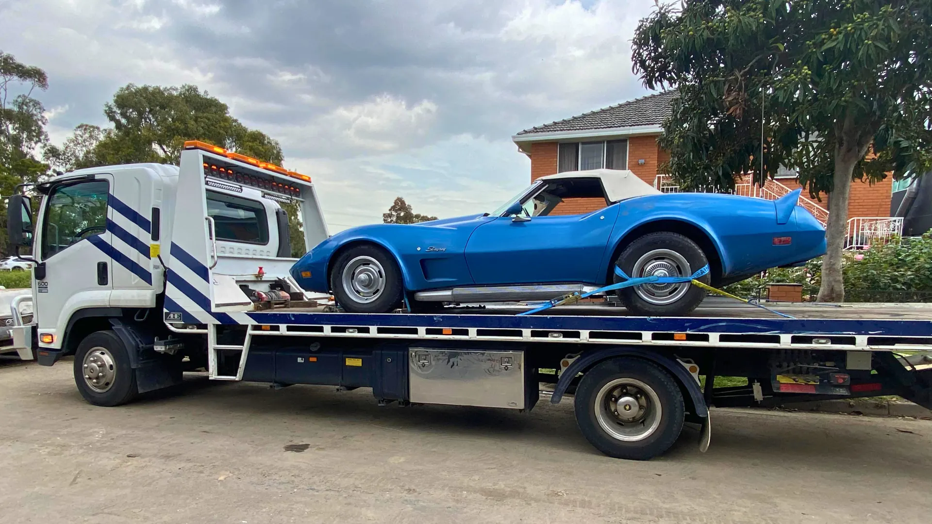 Blue Corvette Stingray secured on the All Over Towing tilt tray