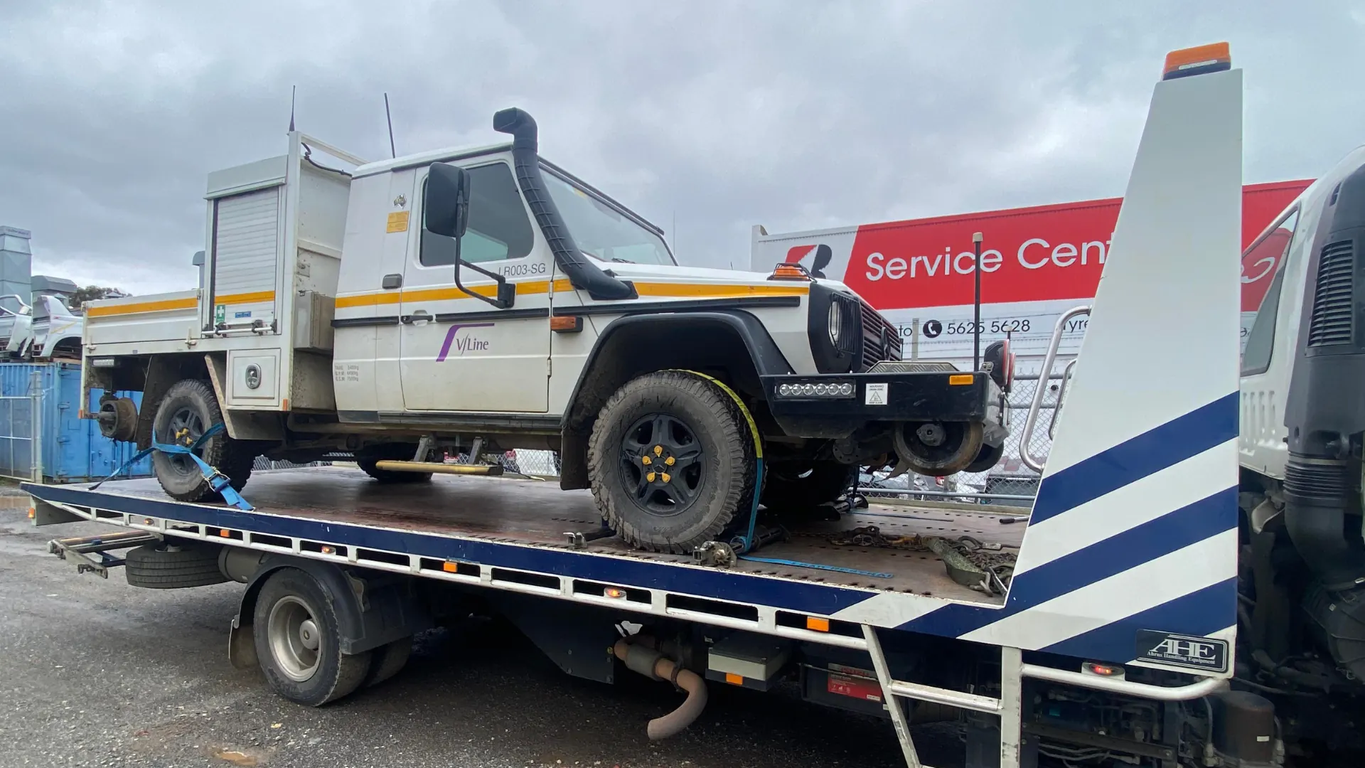 White hi-rail Mercedes G-Wagon on the All Over Towing tilt tray at a service centre