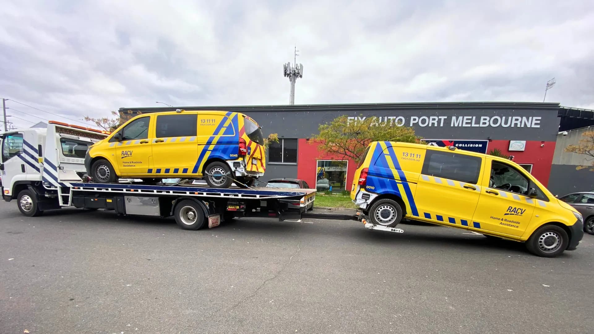 Yellow RACV service van secured on the All Over Towing tilt tray outside a Melbourne auto workshop